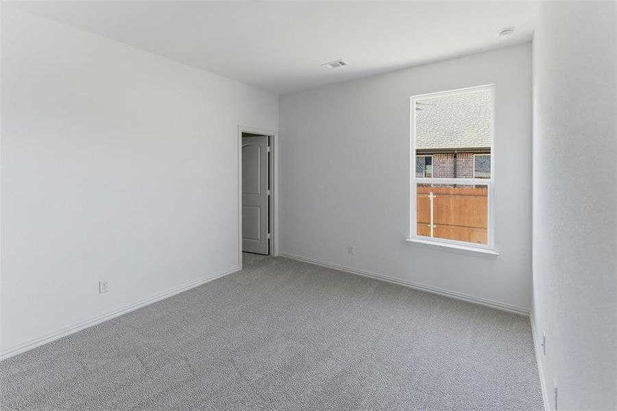 Carpeted spare room with baseboards