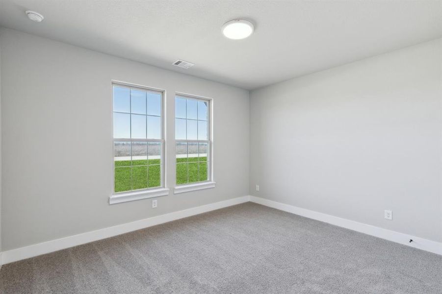 Spare room featuring visible vents, carpet floors, and baseboards