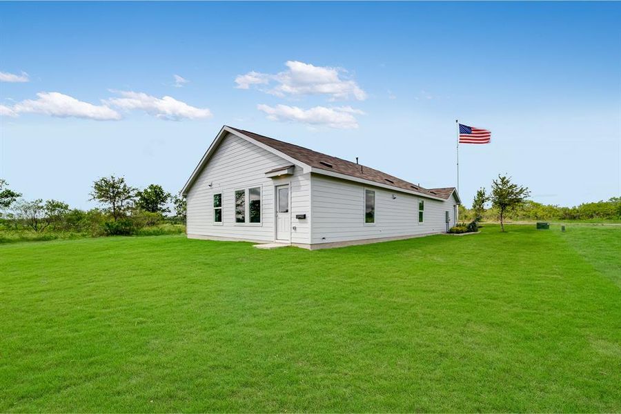 Back of property featuring a yard Back of property featuring a yard