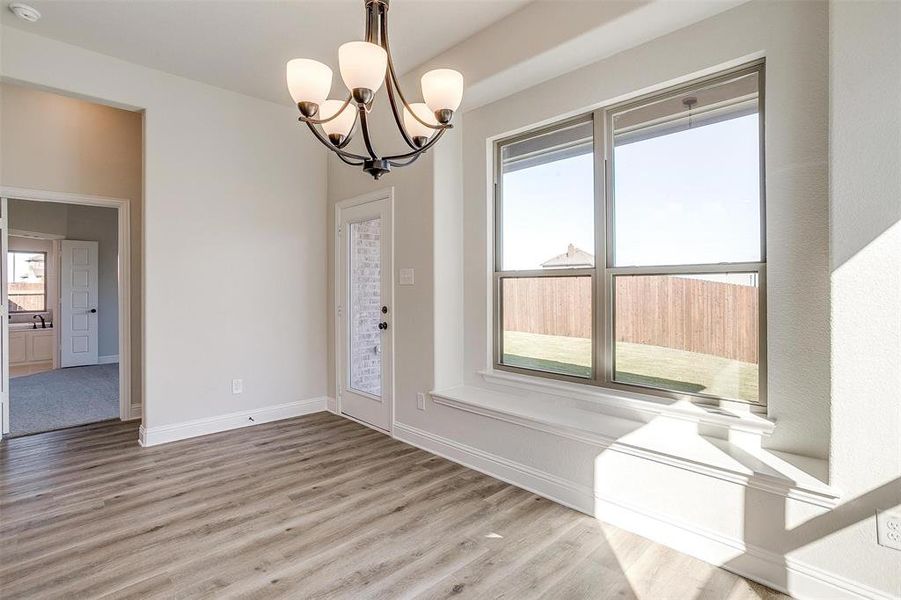 Spare room featuring light hardwood / wood-style flooring and a notable chandelier