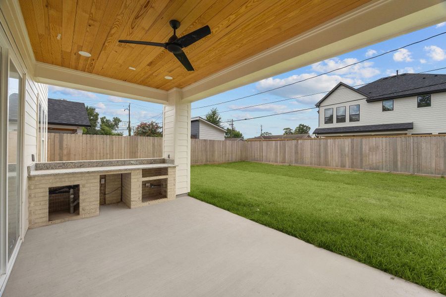 Outside, a covered outdoor kitchen overlooks a generous backyard. Outside, a covered outdoor kitchen overlooks a generous backyard.