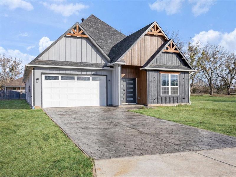 View of front of house with a front lawn, an attached garage, and driveway View of front of house with a front lawn, an attached garage, and driveway