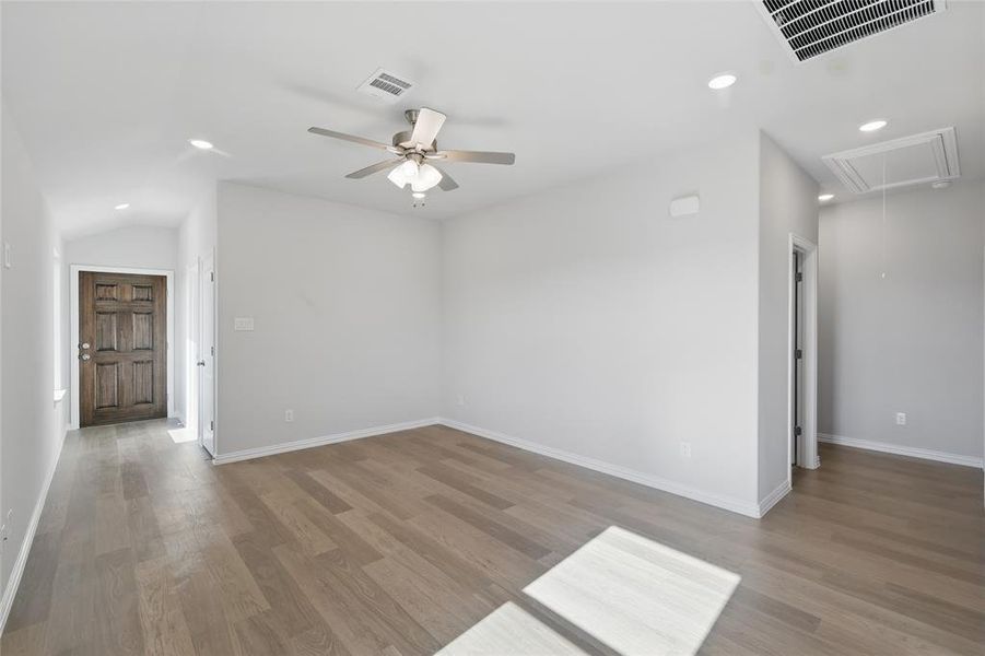 Spare room featuring attic access, ceiling fan, wood finished floors, recessed lighting, and lofted ceiling Spare room featuring attic access, ceiling fan, wood finished floors, recessed lighting, and lofted ceiling
