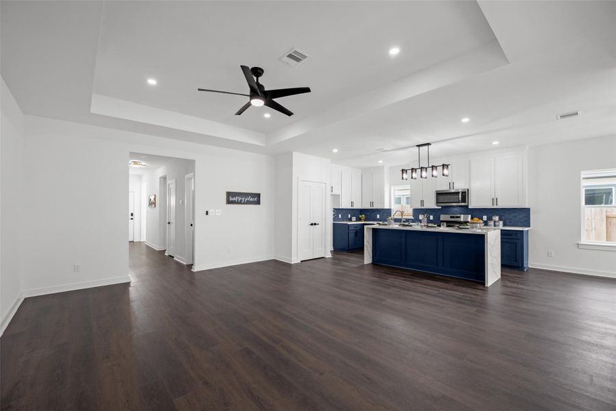 Kitchen boasts sleek white cabinetry, a bold blue island with a marble countertop, and stainless steel appliances. Bright and airy, it offers a contemporary feel ideal for entertaining. Kitchen boasts sleek white cabinetry, a bold blue island with a marble countertop, and stainless steel appliances. Bright and airy, it offers a contemporary feel ideal for entertaining.