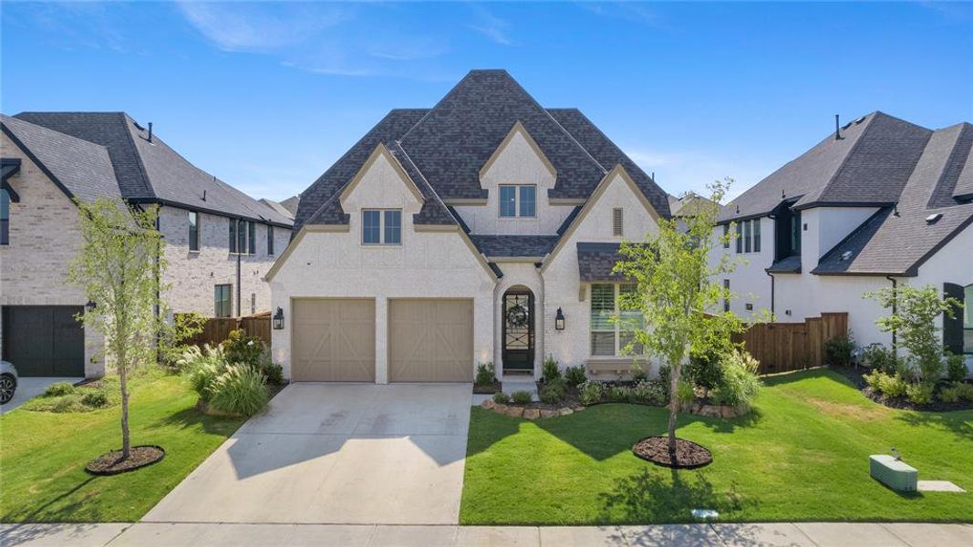 View of front of house featuring a front lawn and a garage