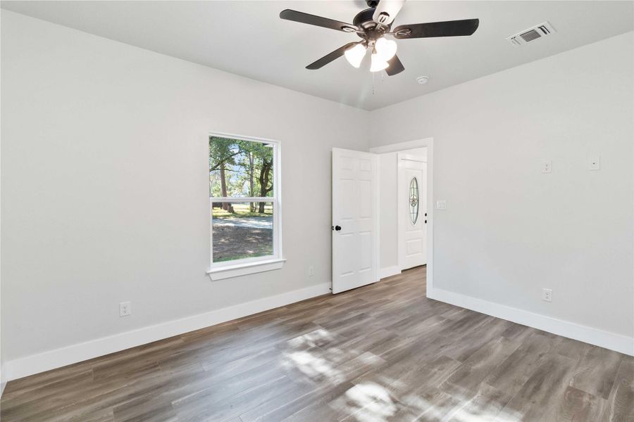 Spare room with wood finished floors and ceiling fan