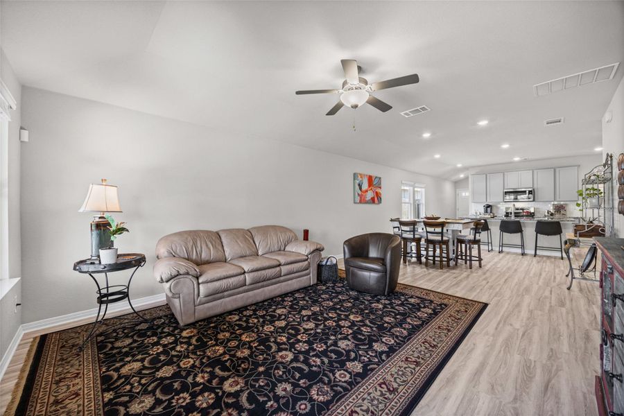 An open floorplan seamlessly connects the comfortable living area with the dining space and kitchen.