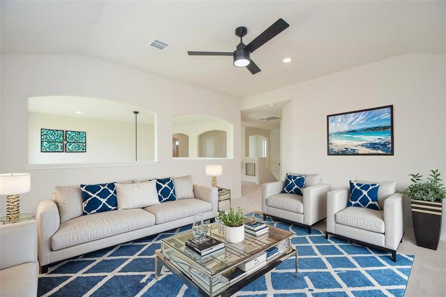 This versatile upstairs bonus room offers endless possibilities, from a cozy media room to a secondary family room. Bright with natural light, the space is defined by modern features like arched cutouts and a sleek ceiling fan, creating an airy and inviting ambiance.