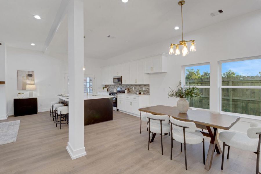 Open-concept design featuring a stylish kitchen with quartz countertops and a spacious dining area. Open-concept design featuring a stylish kitchen with quartz countertops and a spacious dining area.