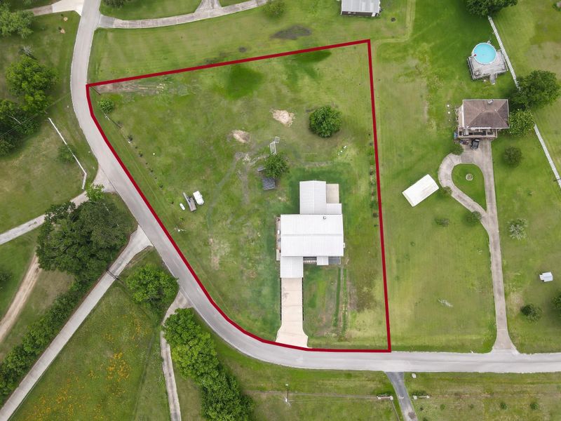 This aerial photo shows a spacious property outlined in red,