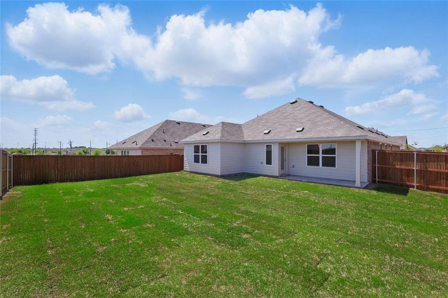 Back of property featuring a yard and a fenced backyard