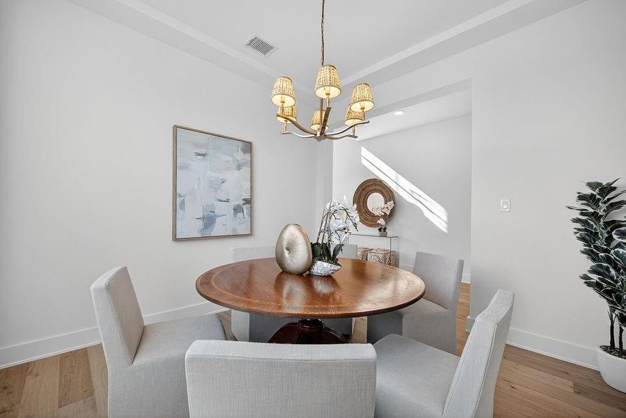 Dining room with wood finished floors and a chandelier Dining room with wood finished floors and a chandelier