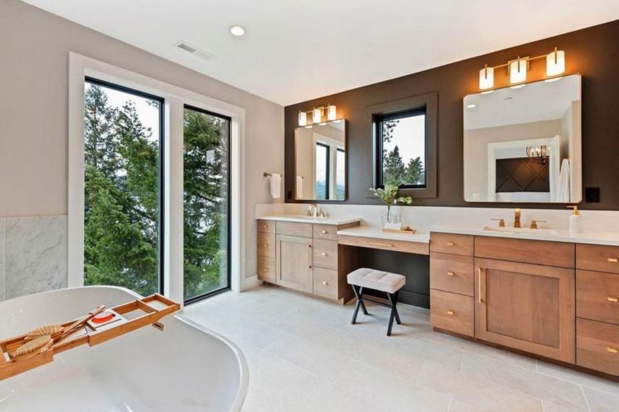 Bathroom with double vanity, a freestanding tub, and recessed lighting