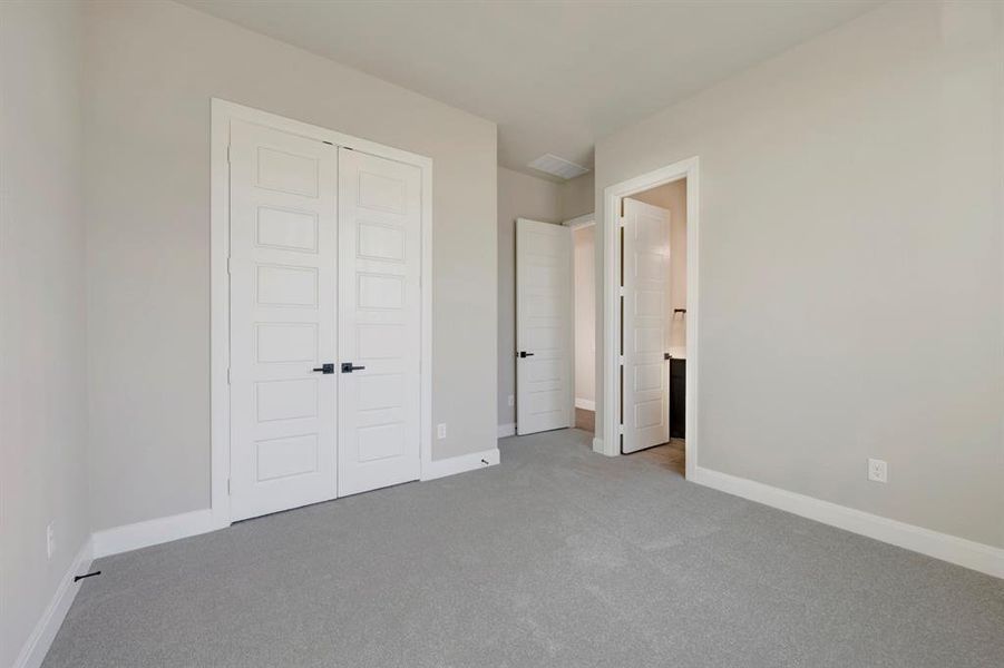 Unfurnished bedroom featuring light carpet and a closet Unfurnished bedroom featuring light carpet and a closet