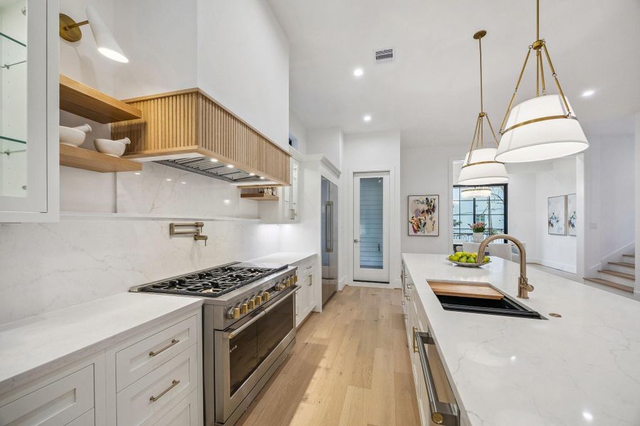 Stainless Steel Appliances Including:  48” GE Monogram Side-By-Side Refrigerator/Freezer, 48” GE Monogram Stainless Steel Range with 6 Gas Burners, Griddle and Double Ovens, Custom Hood with Wood Trim and a 48” GE Stainless Steel Hood Liner, GE Monogram Fully Integrated Dishwasher, GE Monogram Microwave Drawer.  There is an attached covered Balcony with a Gas Connection.  There is also a Walk-In Pantry.