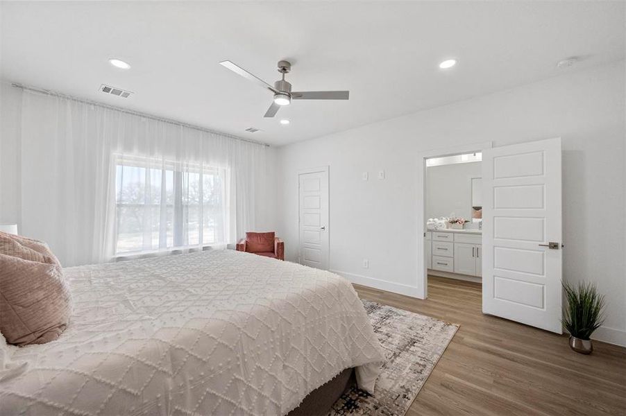 Bedroom with baseboards, light wood-type flooring, visible vents, and recessed lighting