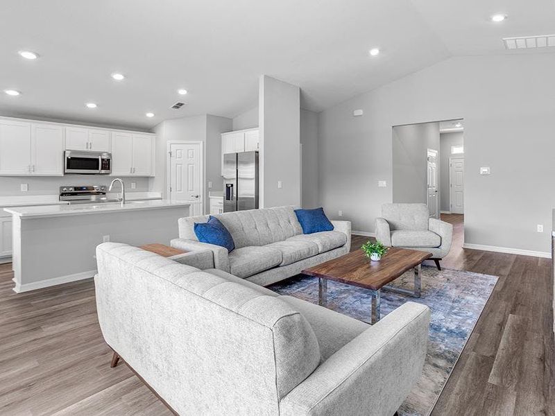 Enjoy a sunny, open living area with volume ceilings and LVP flooring.