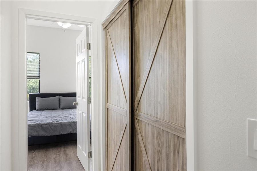 Corridor with a barn door and light hardwood / wood-style flooring