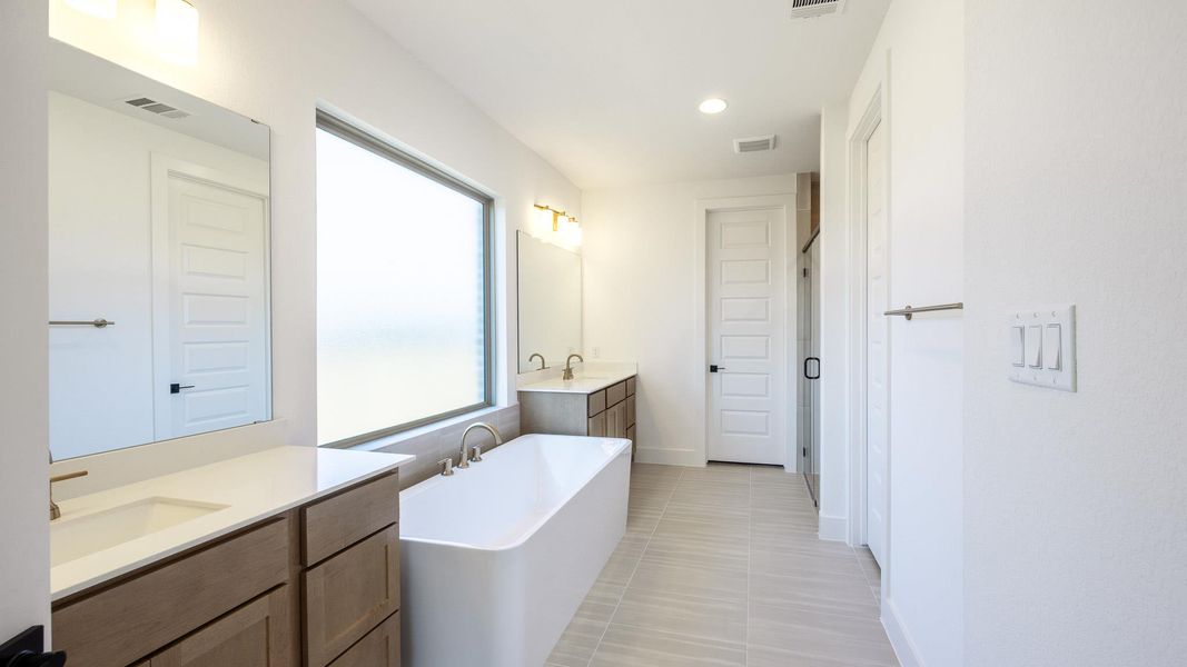 Full bath with two vanities, a freestanding tub, recessed lighting, and light tile patterned flooring Full bath with two vanities, a freestanding tub, recessed lighting, and light tile patterned flooring