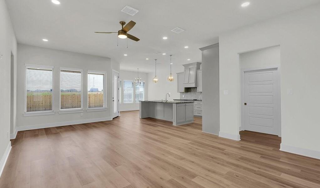 Unfurnished living room featuring ceiling fan, recessed lighting, light wood-type flooring, and a chandelier