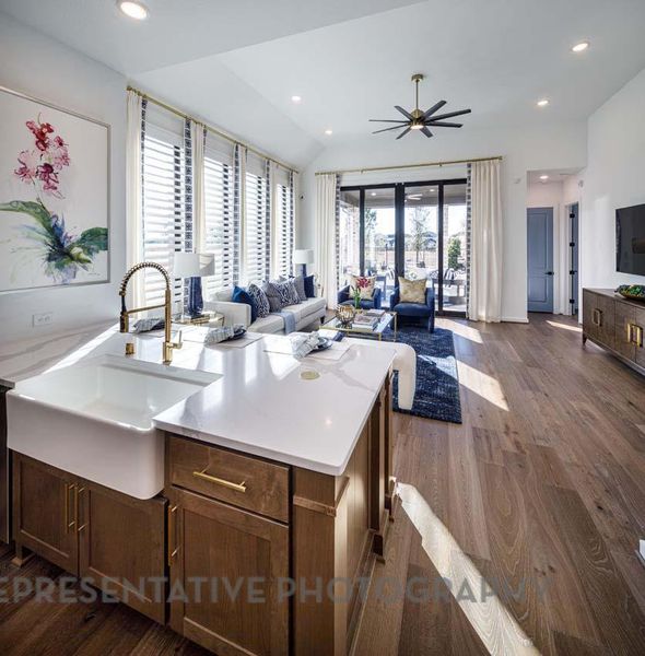 Kitchen with dark wood-style flooring, open floor plan, light countertops, ceiling fan, and recessed lighting Kitchen with dark wood-style flooring, open floor plan, light countertops, ceiling fan, and recessed lighting
