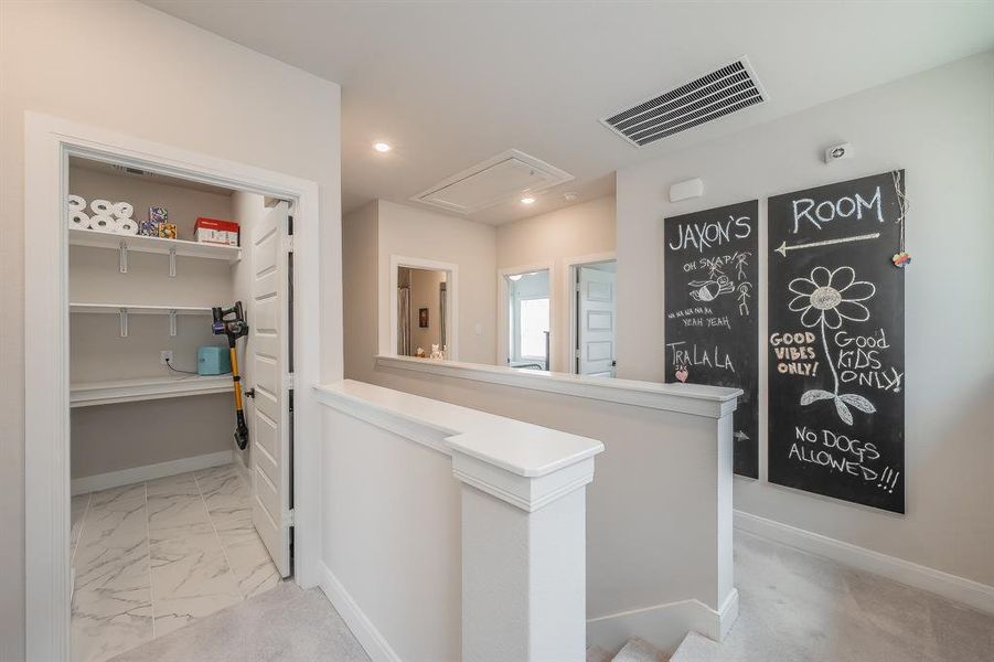 Hall with an upstairs landing, attic access, light marble finish floors, and recessed lighting