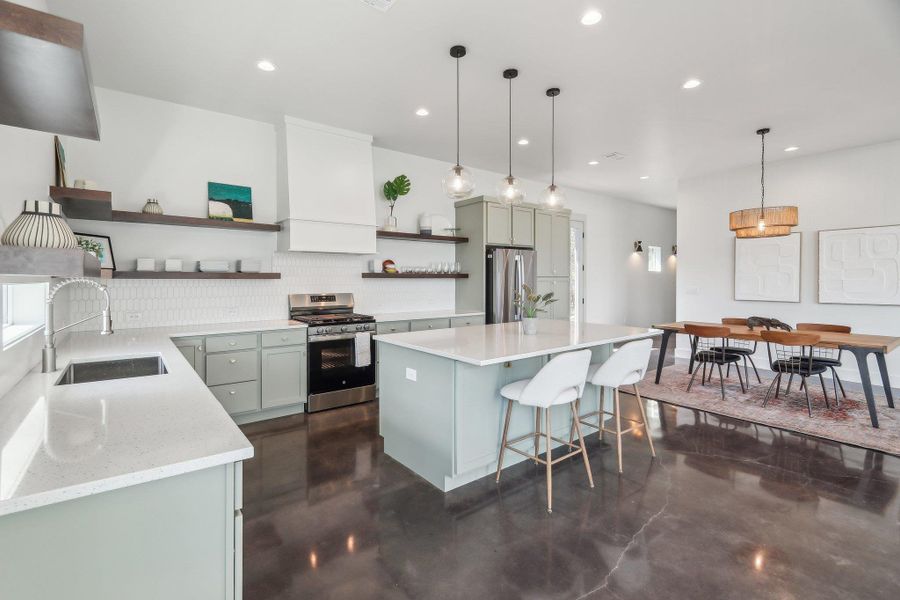 Kitchen with open shelves, stainless steel appliances, a sink, decorative backsplash, and concrete floors Kitchen with open shelves, stainless steel appliances, a sink, decorative backsplash, and concrete floors