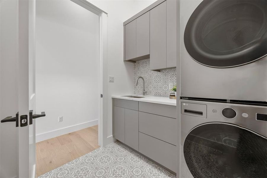 A well-appointed utility area features a functional sink and contemporary laundry appliances.