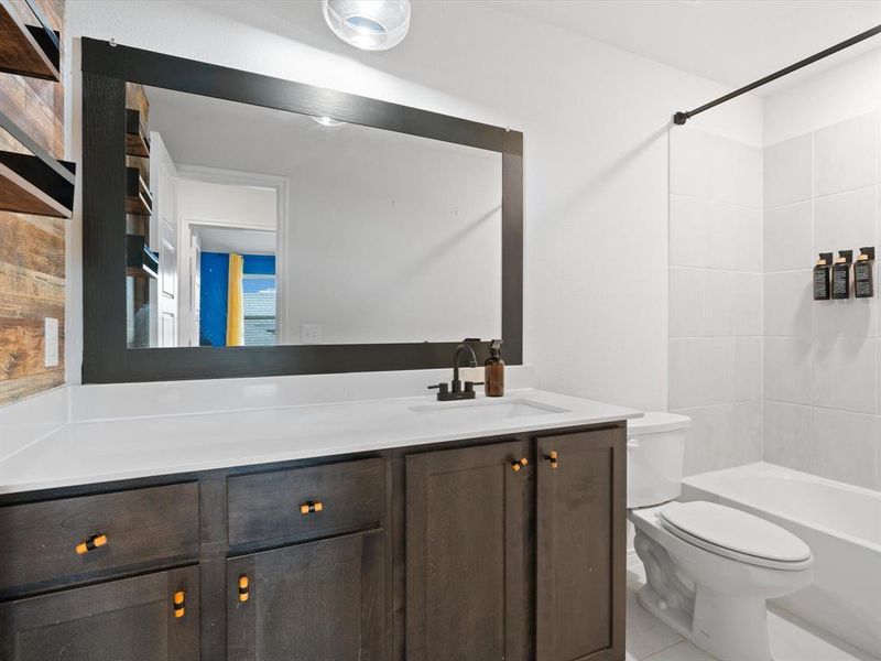 Full bathroom with vanity, tiled shower / bath, and toilet