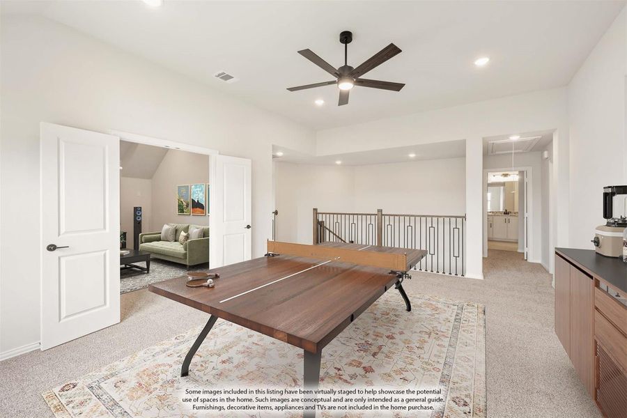Upstairs game room with ping pong table, ceiling fan, carpet flooring, and open staircase railing Upstairs game room with ping pong table, ceiling fan, carpet flooring, and open staircase railing