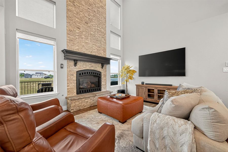 Multiple windows allow natural light to fill the space, highlighting the custom stone fireplace and modern finishes. Multiple windows allow natural light to fill the space, highlighting the custom stone fireplace and modern finishes.