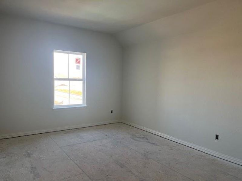 Empty room featuring vaulted ceiling