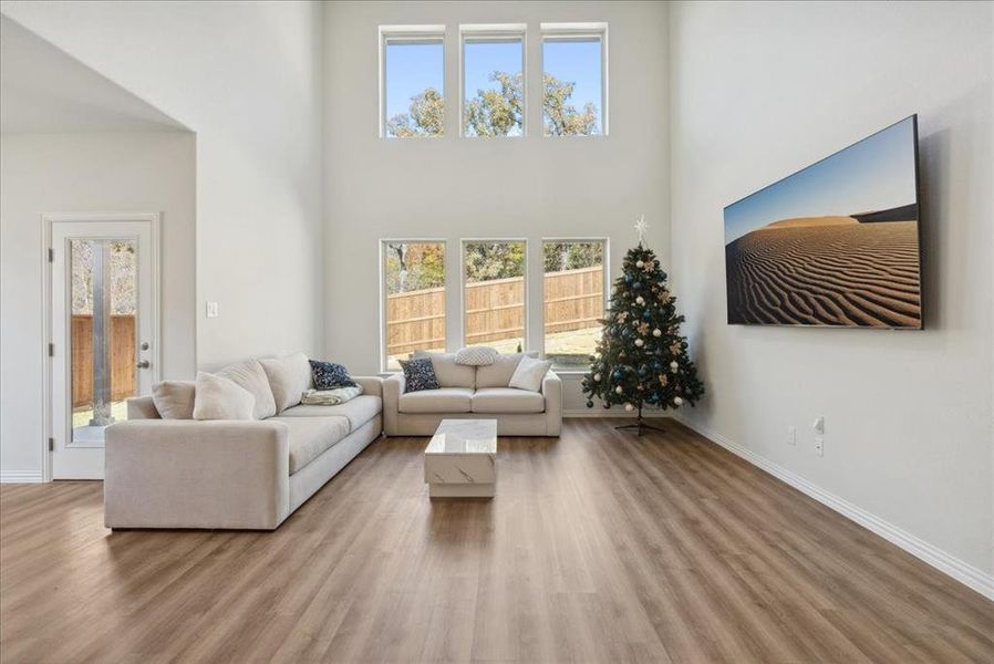 Living room featuring wood-type flooring and a towering ceiling