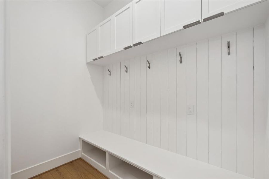 The bright and inviting mudroom offers a clean and classic design. White shiplap walls and crisp white cabinetry create a fresh and airy atmosphere.