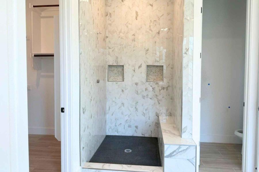 Bathroom featuring a shower stall, wood tiled floors, and a walk in closet Bathroom featuring a shower stall, wood tiled floors, and a walk in closet