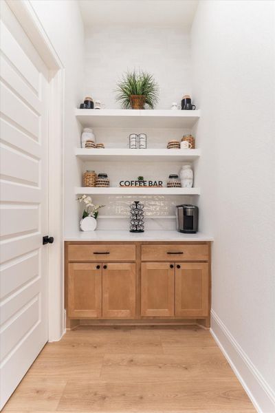 A custom coffee bar and spacious walk-in pantry add convenience and elevated charm to the home.