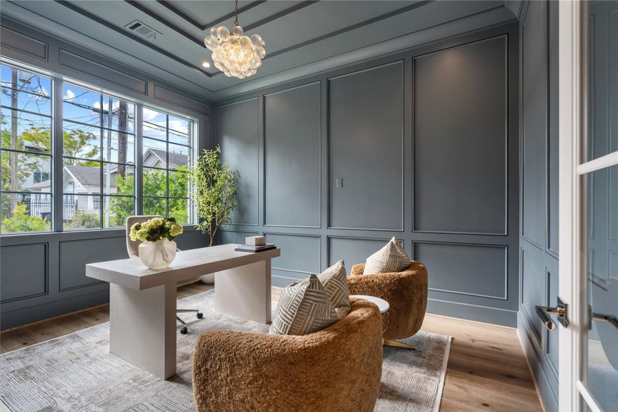Another angle of the office space. The custom, paneled trim adds dimension and elegance to the room and the hand-blown bubble chandelier adds a touch of whimsy. These walls are great for a TV or artwork.