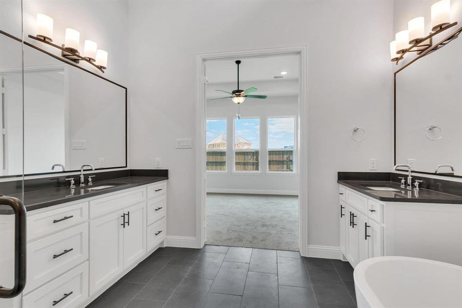 Bathroom featuring ceiling fan, a tub, tile patterned floors, and double sink vanity