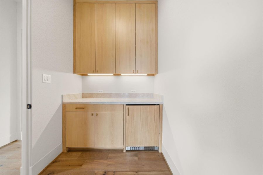 Access to the bar with wine refrigerator as you enter the primary suite.