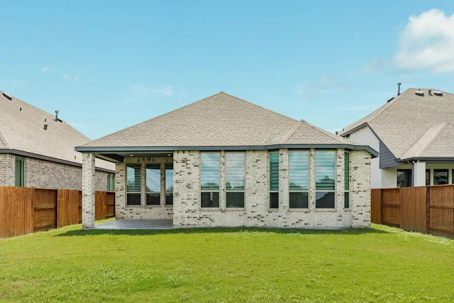Stunning waterfront views define this expansive backyard, featuring a beautifully covered patio that provides the perfect space for outdoor relaxation. Large, elegant bay windows flood the interior with natural light while offering picturesque perspectives of the serene water beyond. The oversized lot ensures plenty of room for activities, making this an ideal setting fo
