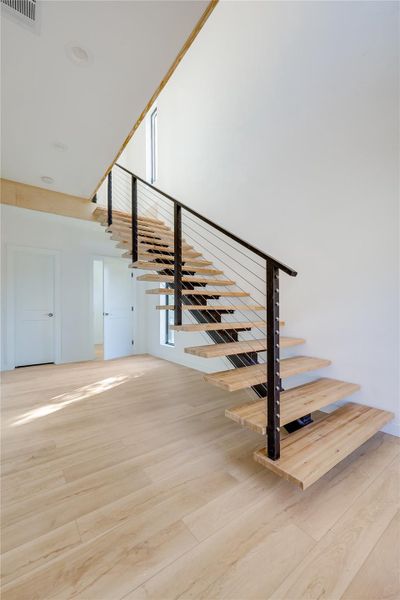 Stairs with wood finished floors and a high ceiling Stairs with wood finished floors and a high ceiling