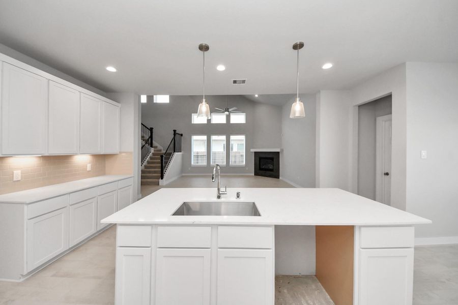 The kitchen is a culinary haven, featuring granite countertops, a tile backsplash, stainless steel appliances, 42” upper cabinets, and undercabinet lighting.