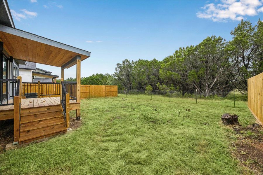 A spacious backyard awaits, featuring a covered deck perfect for outdoor enjoyment. A spacious backyard awaits, featuring a covered deck perfect for outdoor enjoyment.