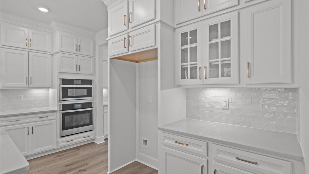 Superior kitchen with quartz countertops, pendant lighting, and a generously sized island