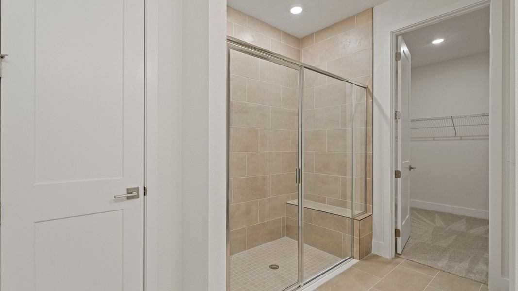 Primary Bathroom with roman shower upgrade in the Buttonwood floorplan by DRB Homes at Lakeside at Satilla in Saint Cloud, FL