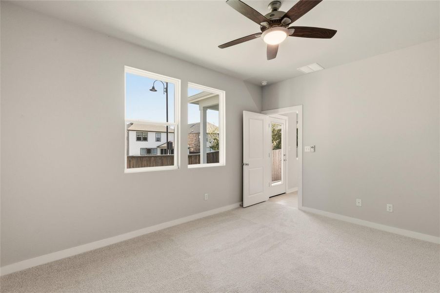 Unfurnished room with light colored carpet and a ceiling fan