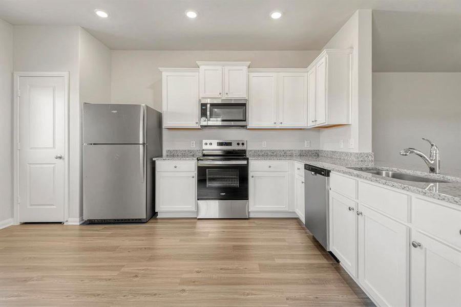 The kitchen is upgraded with Whirlpool appliances and granite countertops.