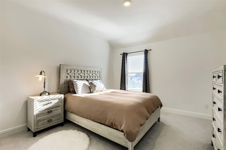 A tranquil bedroom provides a private sanctuary, featuring light-colored carpet and a sun-filled window with blinds. A tranquil bedroom provides a private sanctuary, featuring light-colored carpet and a sun-filled window with blinds.