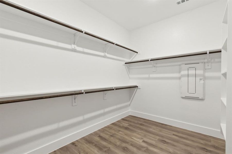 Spacious closet with wood finished floors and electric panel Spacious closet with wood finished floors and electric panel