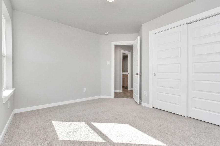 Generously sized secondary bedrooms featuring spacious closets, soft and inviting carpeting underfoot, large windows allowing plenty of natural light, and the added touch of privacy blinds for your personal retreat. Sample photo of completed home with similar floor plan. As-built interior colors and selections may vary. Generously sized secondary bedrooms featuring spacious closets, soft and inviting carpeting underfoot, large windows allowing plenty of natural light, and the added touch of privacy blinds for your personal retreat. Sample photo of completed home with similar floor plan. As-built interior colors and selections may vary.